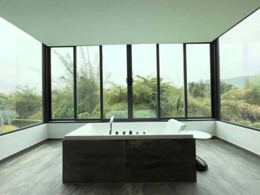 Spacious bathroom with large windows and a bathtub