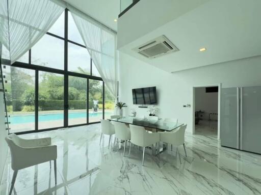 Modern dining area with large windows and pool view