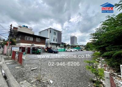 Empty lot with parking and buildings in the background