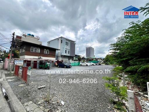 Empty lot with parking and buildings in the background