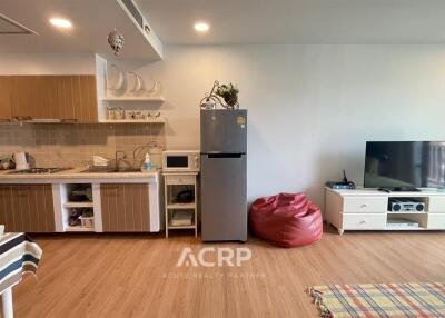 Main living space with an integrated kitchen, dining table, and entertainment area