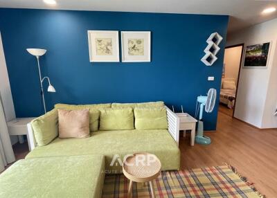 cozy living room with green sofa and blue accent wall