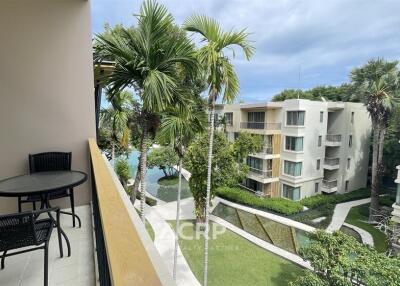 Balcony with outdoor seating overlooking pool and garden area