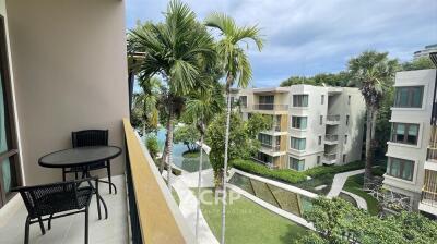 Balcony with outdoor seating overlooking pool and garden area