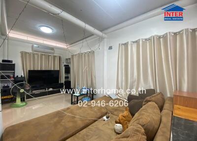 Living room with sectional sofa, TV, and curtains