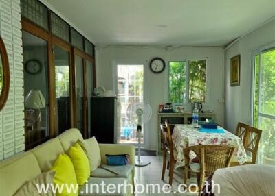 Living room and dining area with large windows and sofa