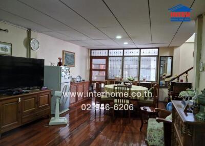 Spacious living room with wooden flooring and dining area.