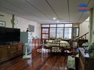 Spacious living room with wooden flooring and dining area.