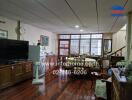 Spacious living room with wooden flooring and dining area.