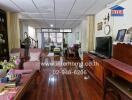 Spacious living room with wooden floor, TV, and comfortable seating