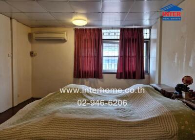 Bedroom with double bed, air conditioning, and window with curtains