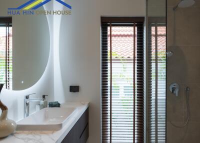 Modern bathroom with sink, mirror, blinds, and a shower