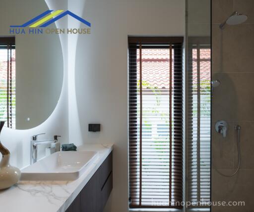 Modern bathroom with sink, mirror, blinds, and a shower