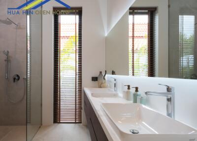 Modern bathroom with dual sinks and walk-in shower