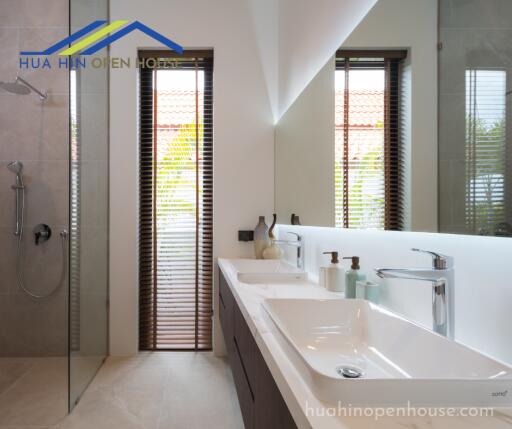 Modern bathroom with dual sinks and walk-in shower