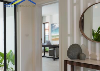 View of a hallway with a small console table and a doorway leading to another room