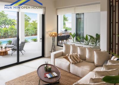 Bright living room with large windows overlooking a pool