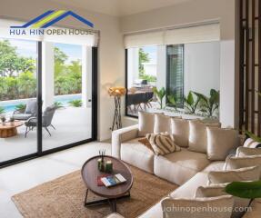 Bright living room with large windows overlooking a pool