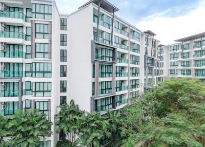 Exterior view of a modern apartment building with green landscaped areas