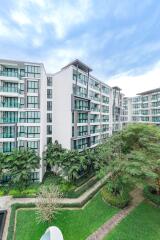 Exterior view of a modern apartment building with green landscaped areas