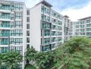 Exterior view of a modern apartment building with green landscaped areas