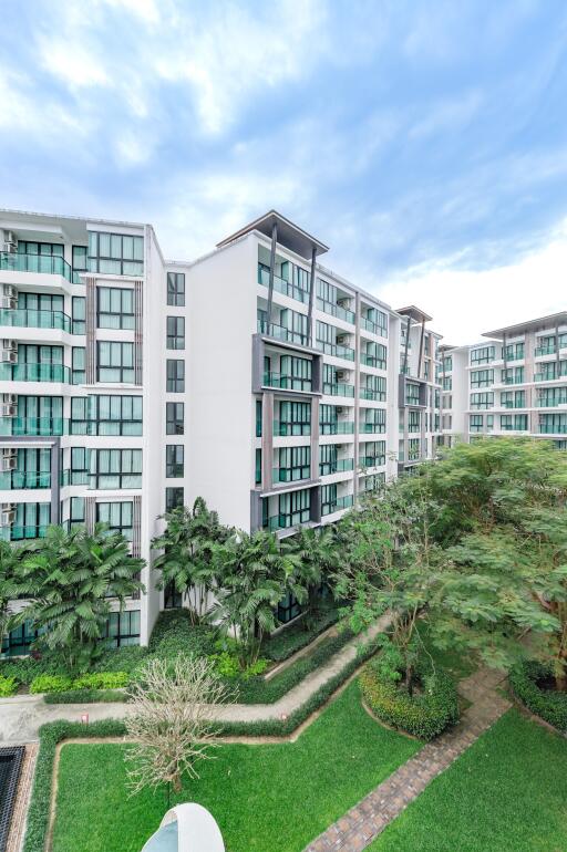 Exterior view of a modern apartment building with green landscaped areas