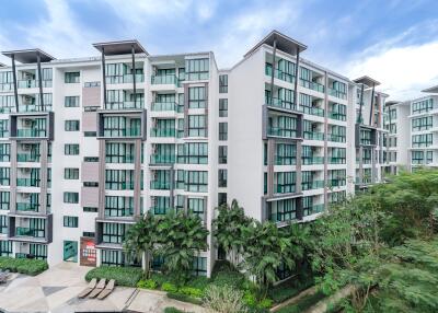 Exterior view of modern apartment complex with balconies and green surrounding