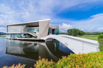 Modern waterfront house with unique architectural design and bridge