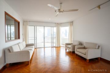 Spacious living room with wooden flooring and large windows