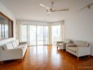 Spacious living room with wooden flooring and large windows