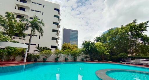 Outdoor swimming pool with view of surrounding buildings and greenery