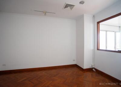 Empty bedroom with wood flooring and large window