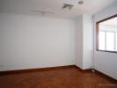 Empty bedroom with wood flooring and large window