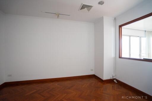 Empty bedroom with wood flooring and large window