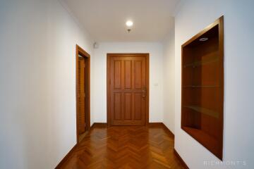 Wooden door in a white-painted hallway with a small display niche