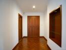 Wooden door in a white-painted hallway with a small display niche