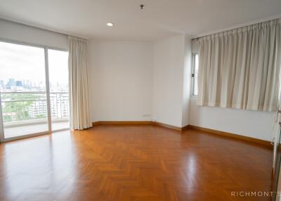 Spacious living room with hardwood flooring and large windows