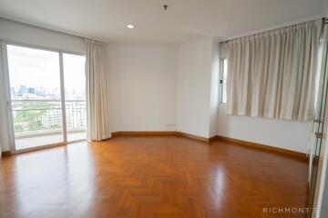 Spacious living room with hardwood flooring and large windows