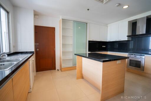 Well-lit modern kitchen with wooden cabinetry and island