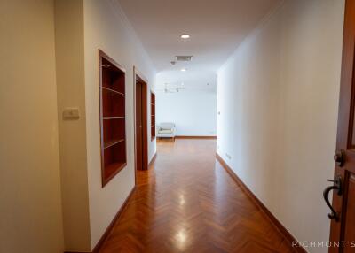 Bright hallway with wooden floors and built-in shelves