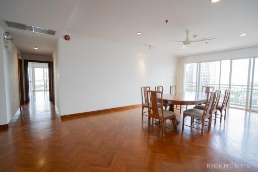 Spacious dining area in an open floor plan with wooden flooring and large windows