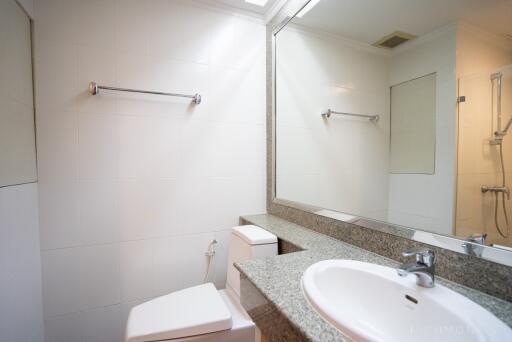 Clean and modern bathroom with granite countertop and large mirror