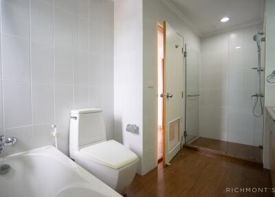 Modern bathroom with a bathtub, toilet, and glass shower