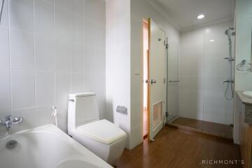 Modern bathroom with a bathtub, toilet, and glass shower