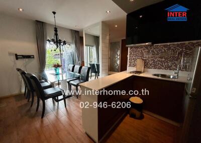 Modern kitchen and dining area with chandelier and large windows