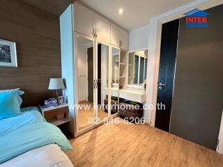 Bedroom with modern furnishing and built-in wardrobe, featuring wooden floors and a vanity area.