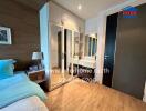 Bedroom with modern furnishing and built-in wardrobe, featuring wooden floors and a vanity area.