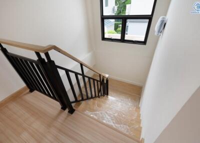 Indoor staircase with wooden steps and black railing