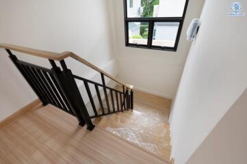 Indoor staircase with wooden steps and black railing