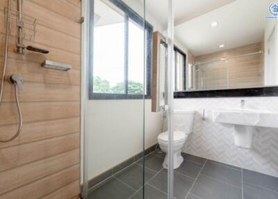 Modern bathroom with glass shower enclosure and large window